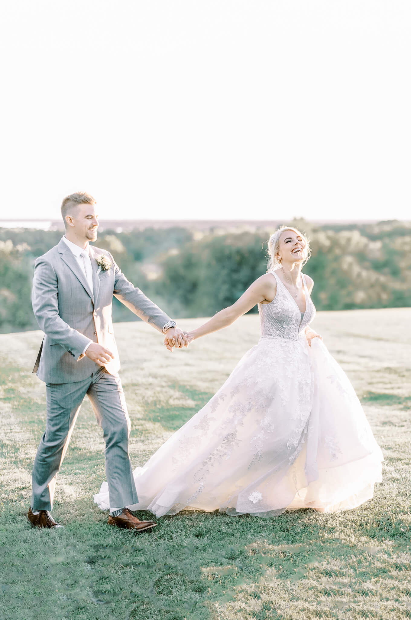bride and groom walking through a field at the Olde Brenton Inn
