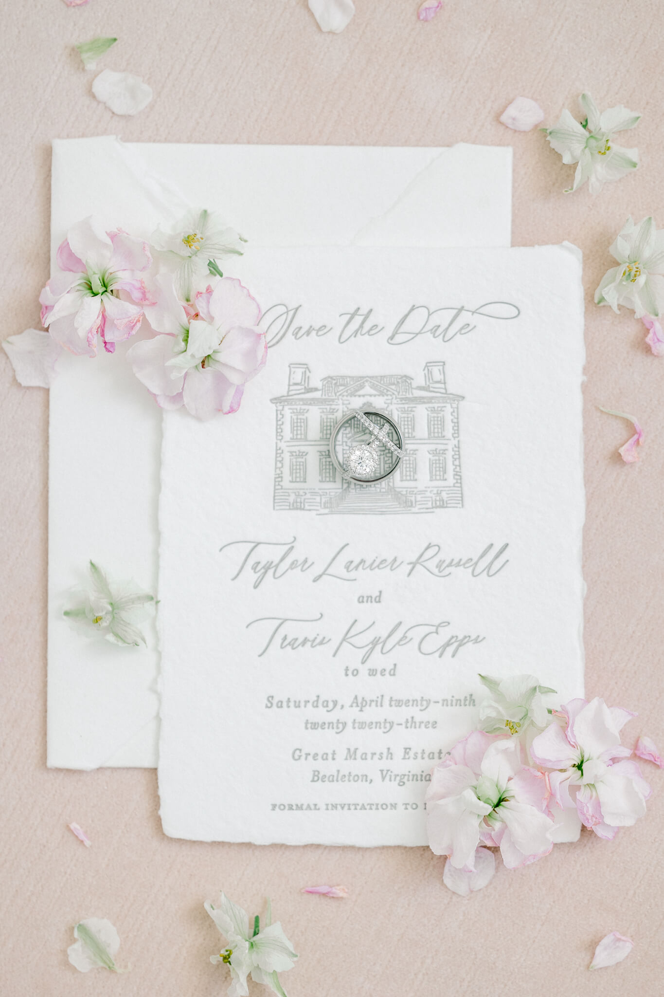 fine art photograph of wedding invitation with rings and flowers