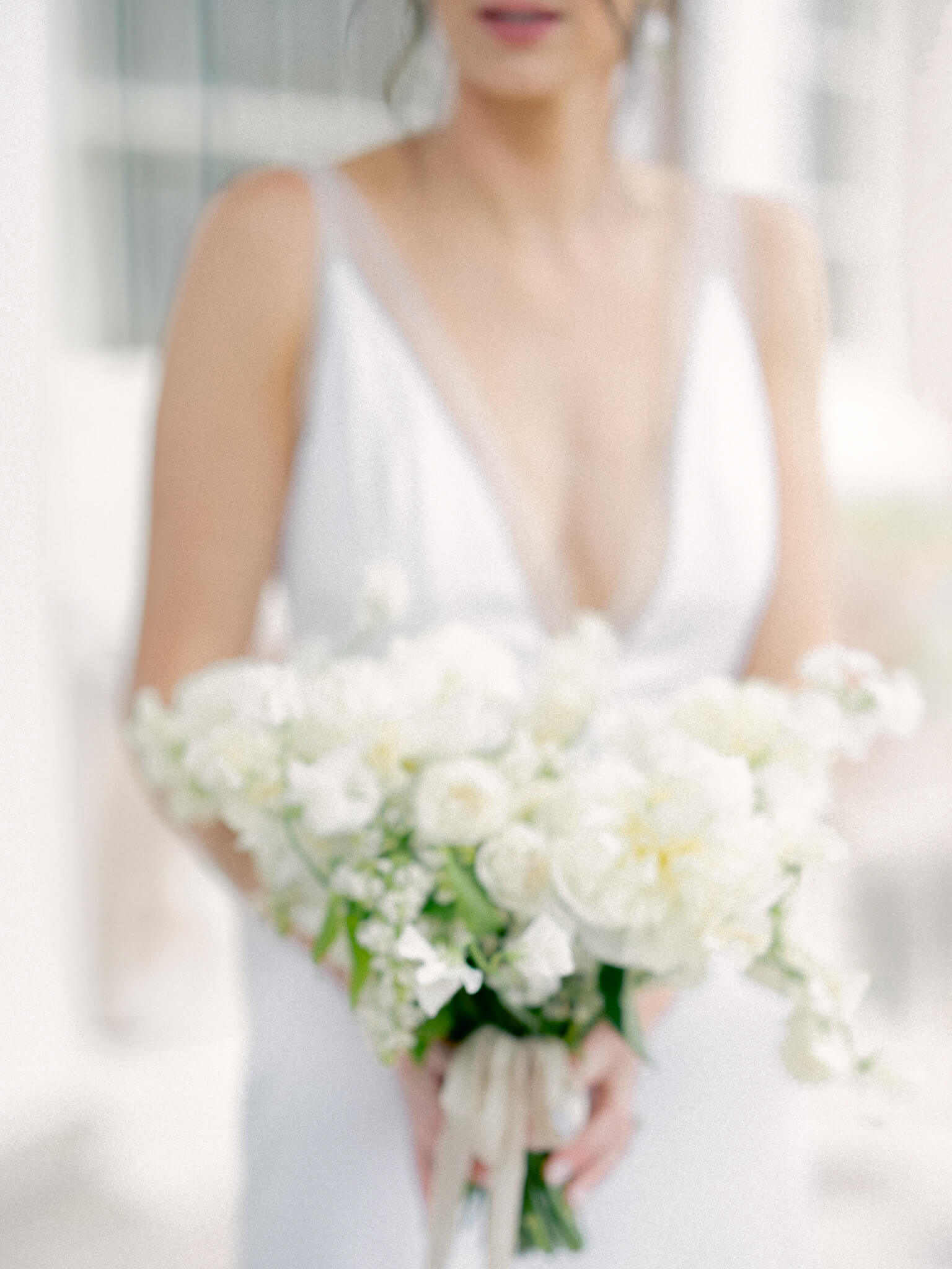Closeup of a bride holding a white bouquet