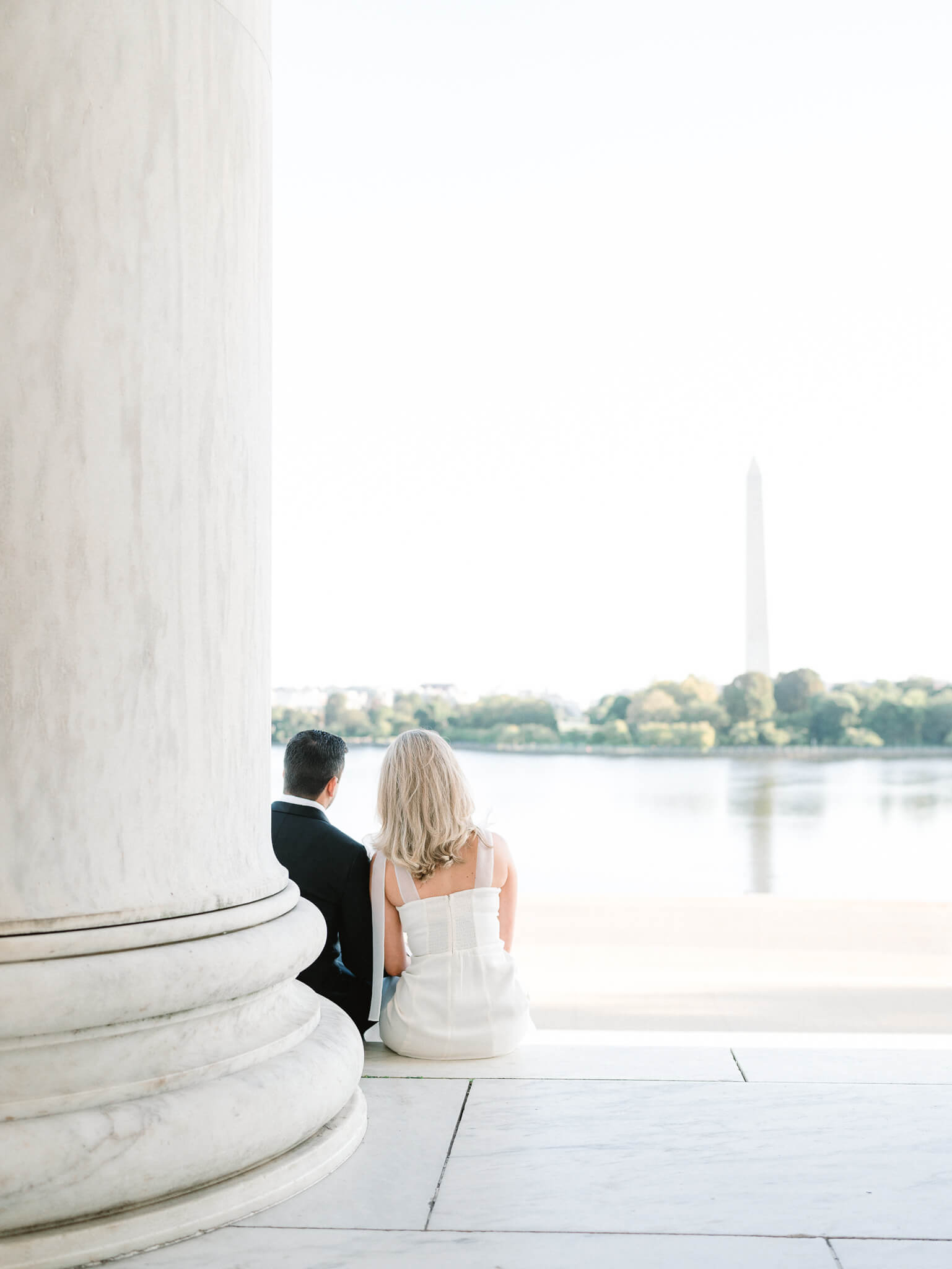 An engaged couple sitting and overlooking the Tidal Basin.