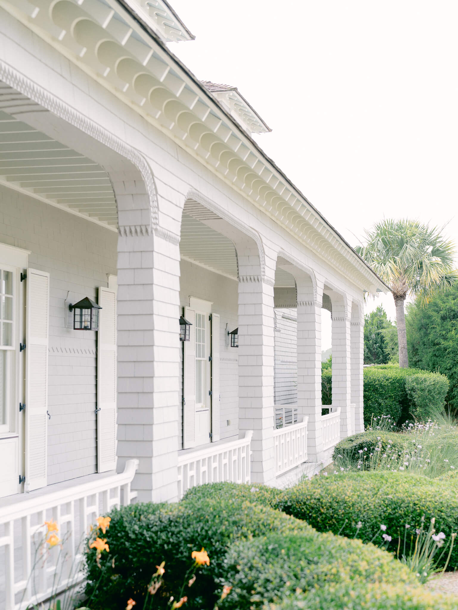 The side porch of Kiawah Island Resort with it's columns and low green shrubs.