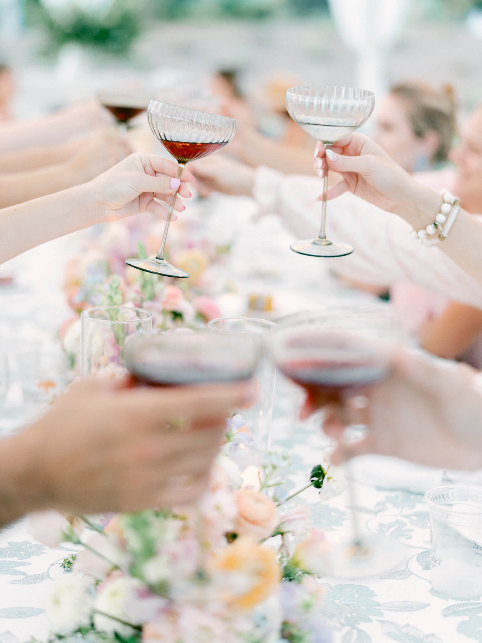 Close up of guests touching their champagne glasses together to cheers.