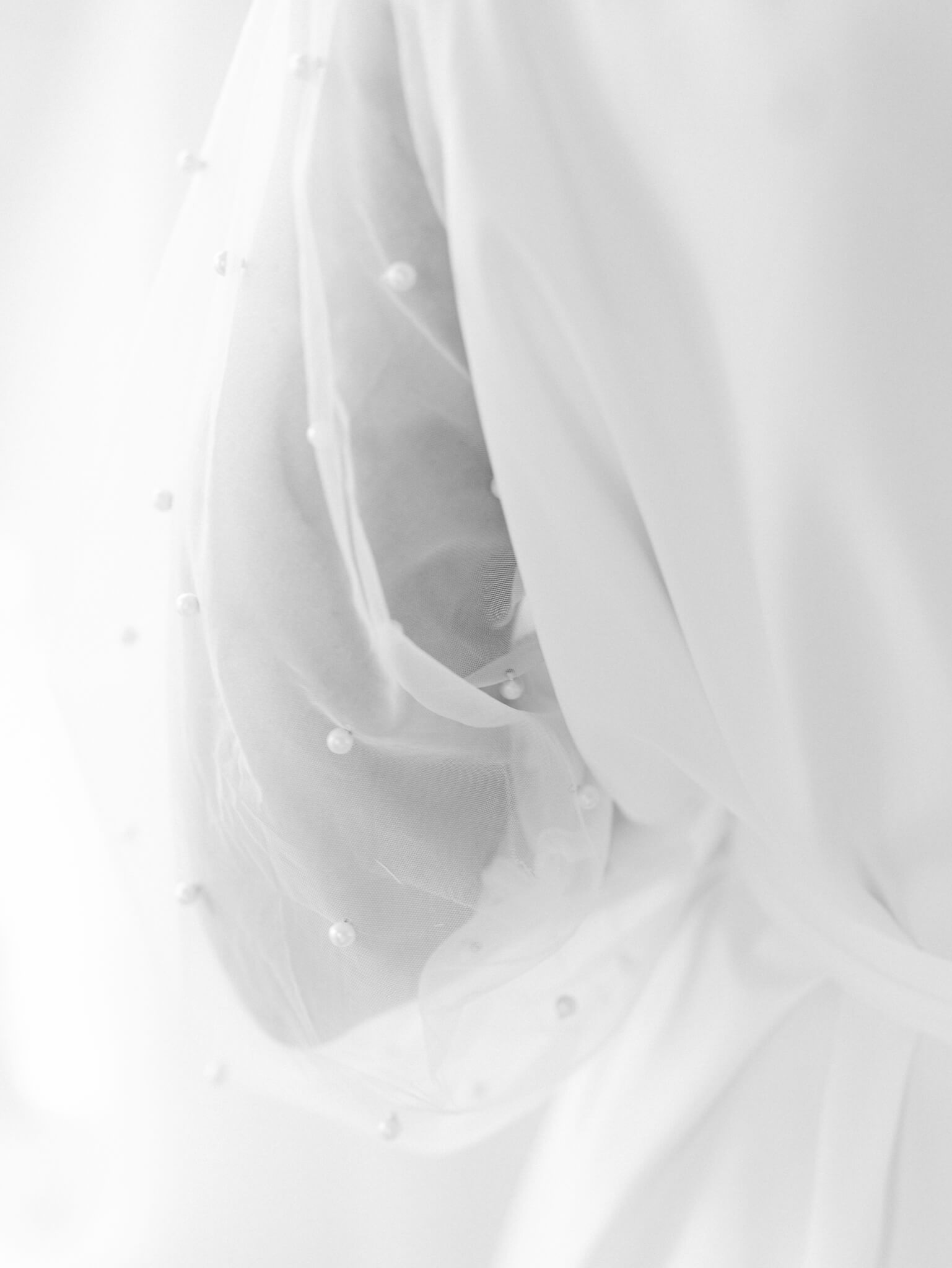 Close up of the pearl detail on a bride's robe in black and white.