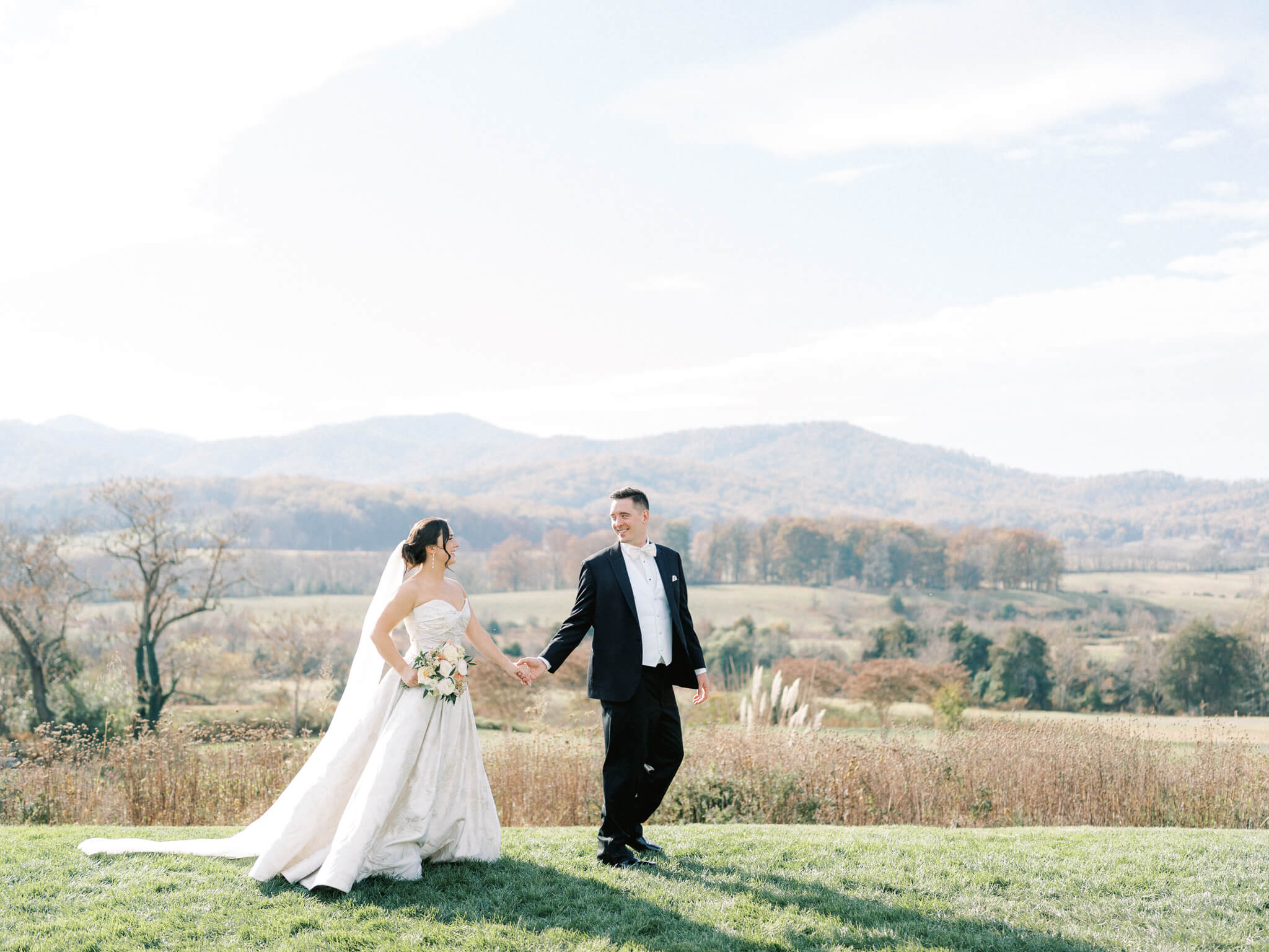 A groom leading his bride in front of the stunning mountain views at a Pippin Hill wedding.