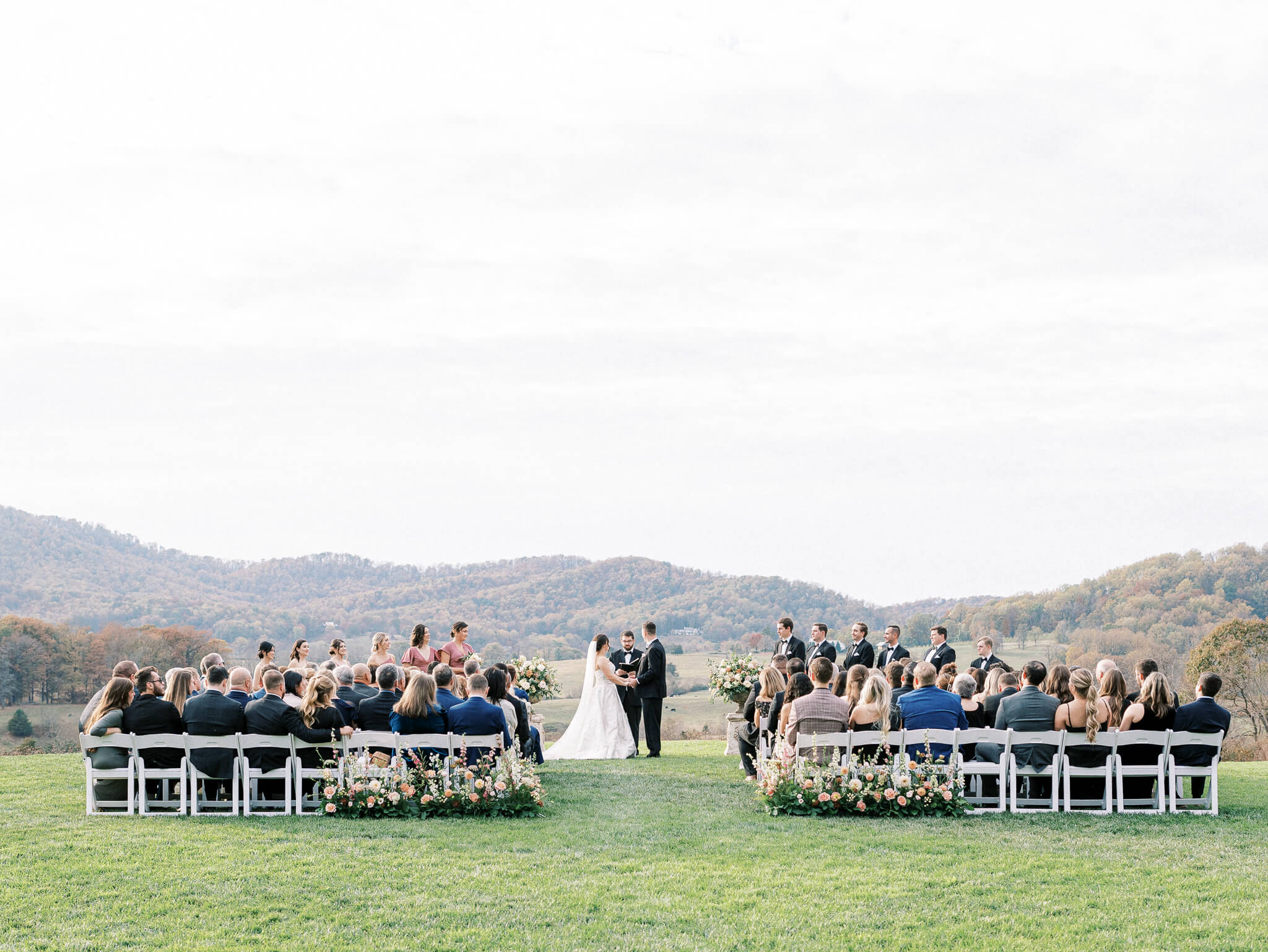 A full image of a wedding ceremony at Pippin Hill Vineyards in front of the Blue Ridge mountains.