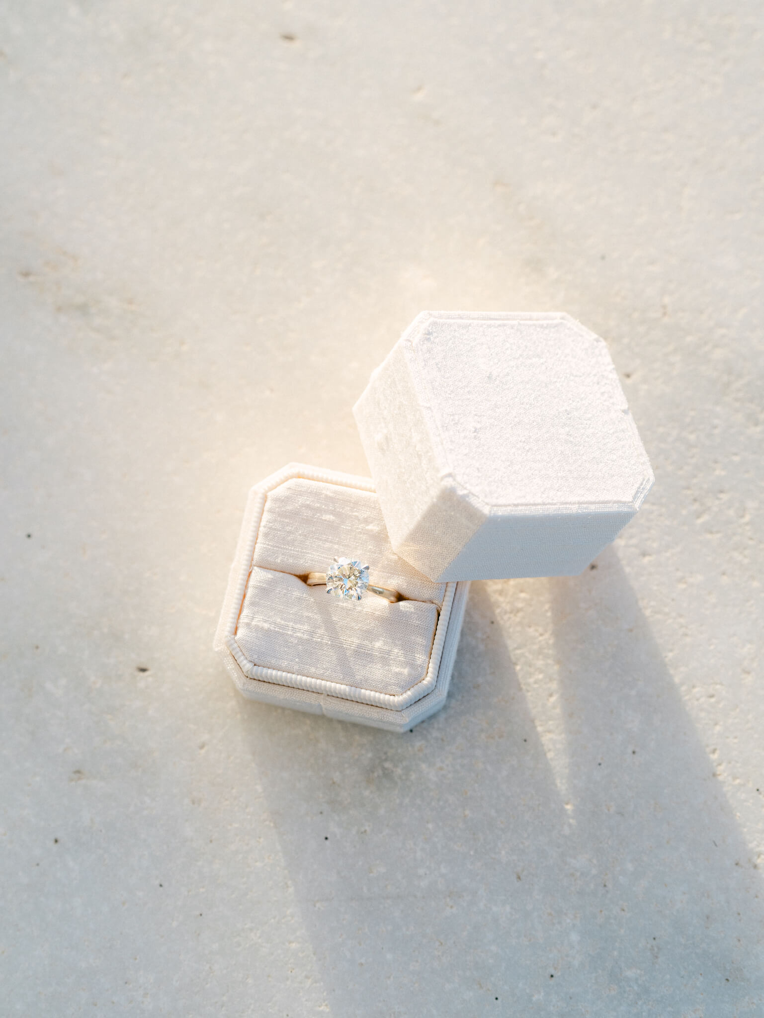 Closeup of an engagement ring in a white ring box.