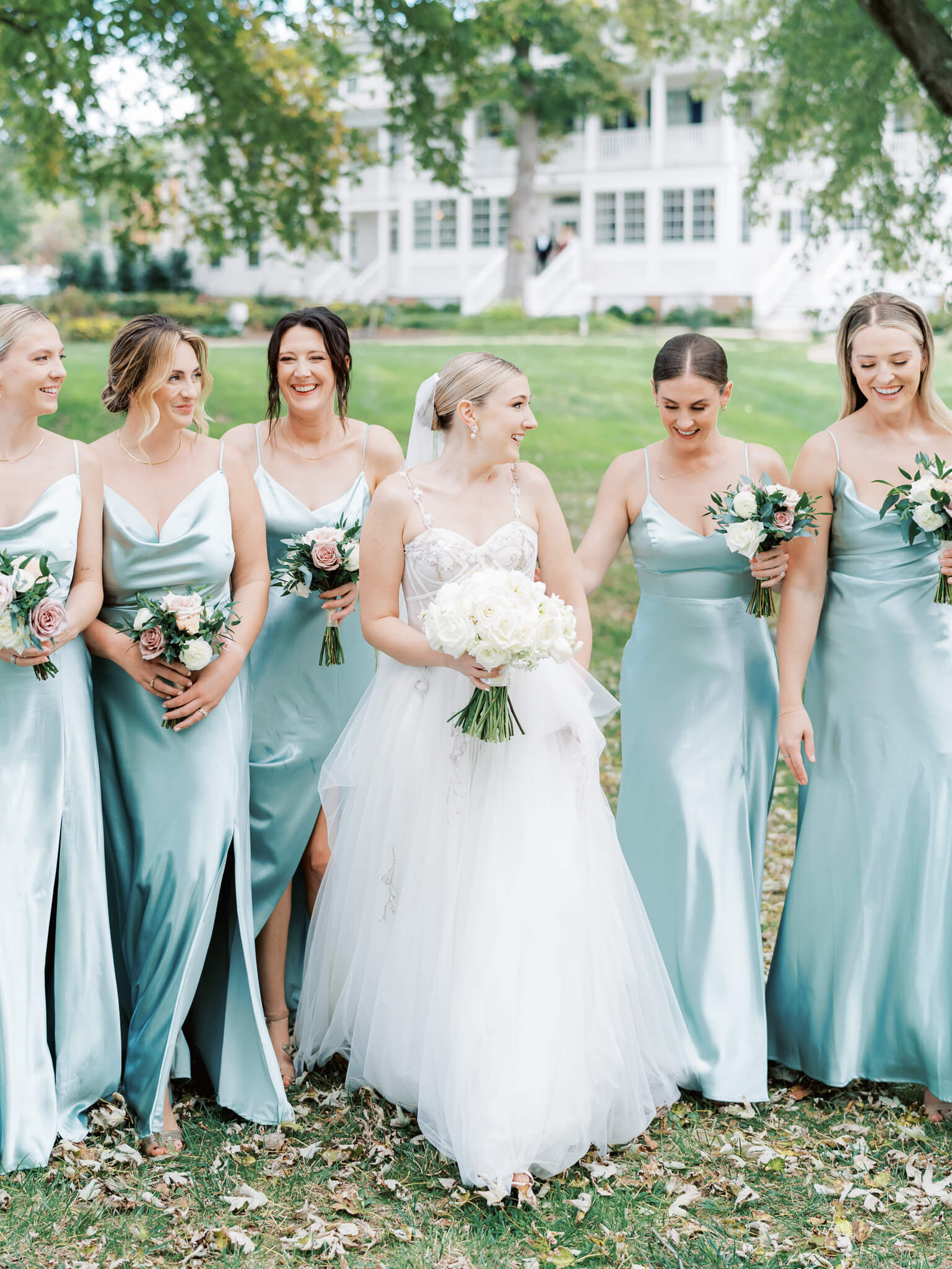 A bride and her bridesmaids walking on the lawn of Kent Island Resort