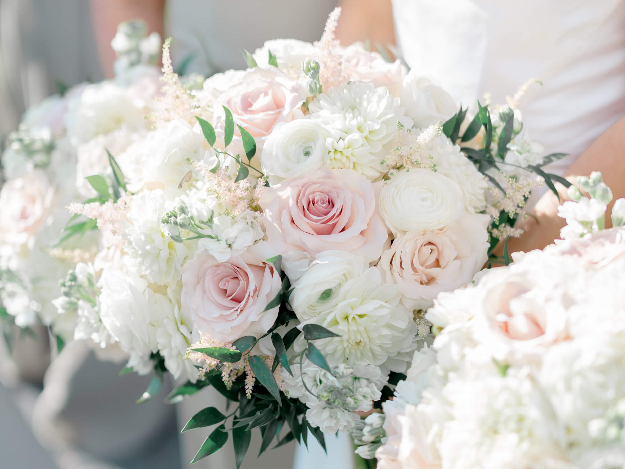 Close-up image of blush, white, cream and green bouquets held by the bride and her bridesmaids.
