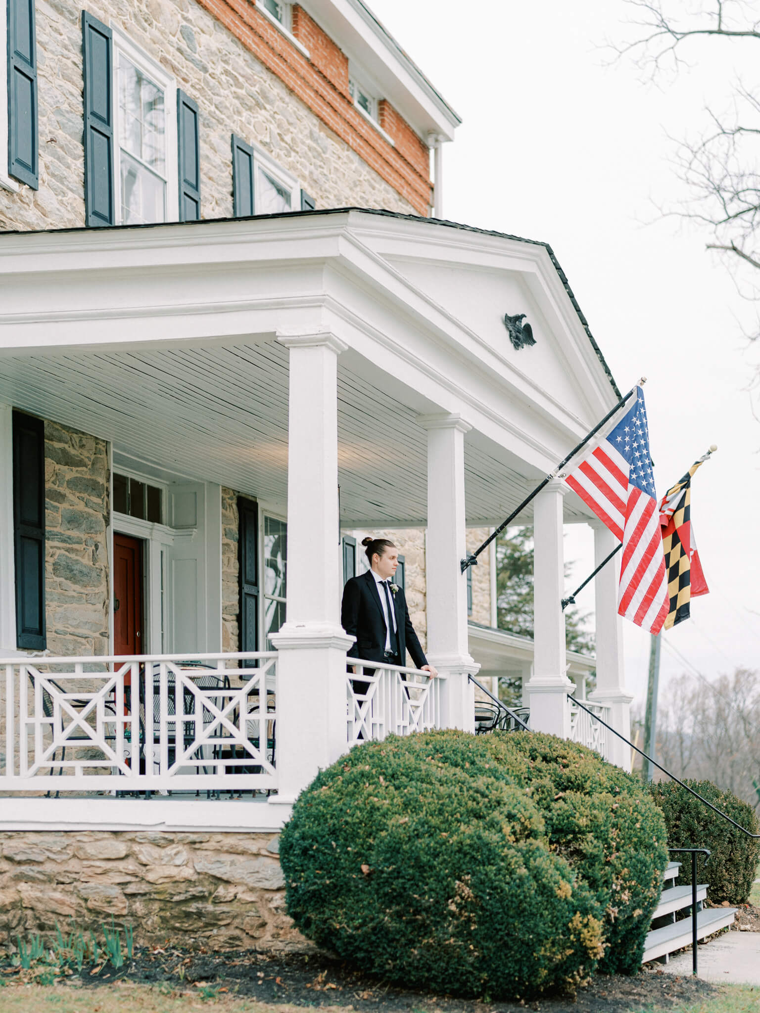 The groom standing on the front porch of Springfield Manor's historic main house.
