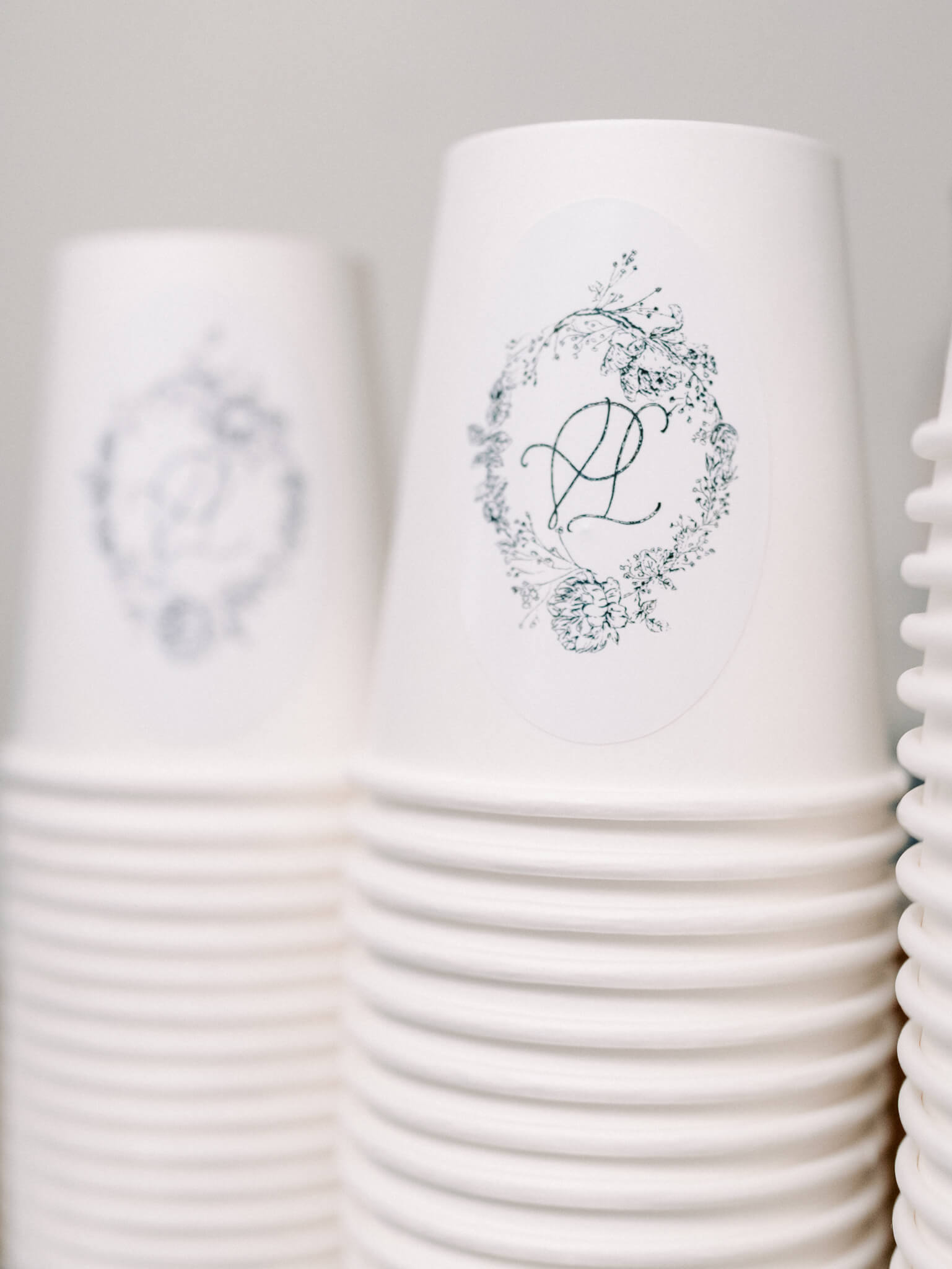 Close up of the couple's monogrammed paper coffee mugs.