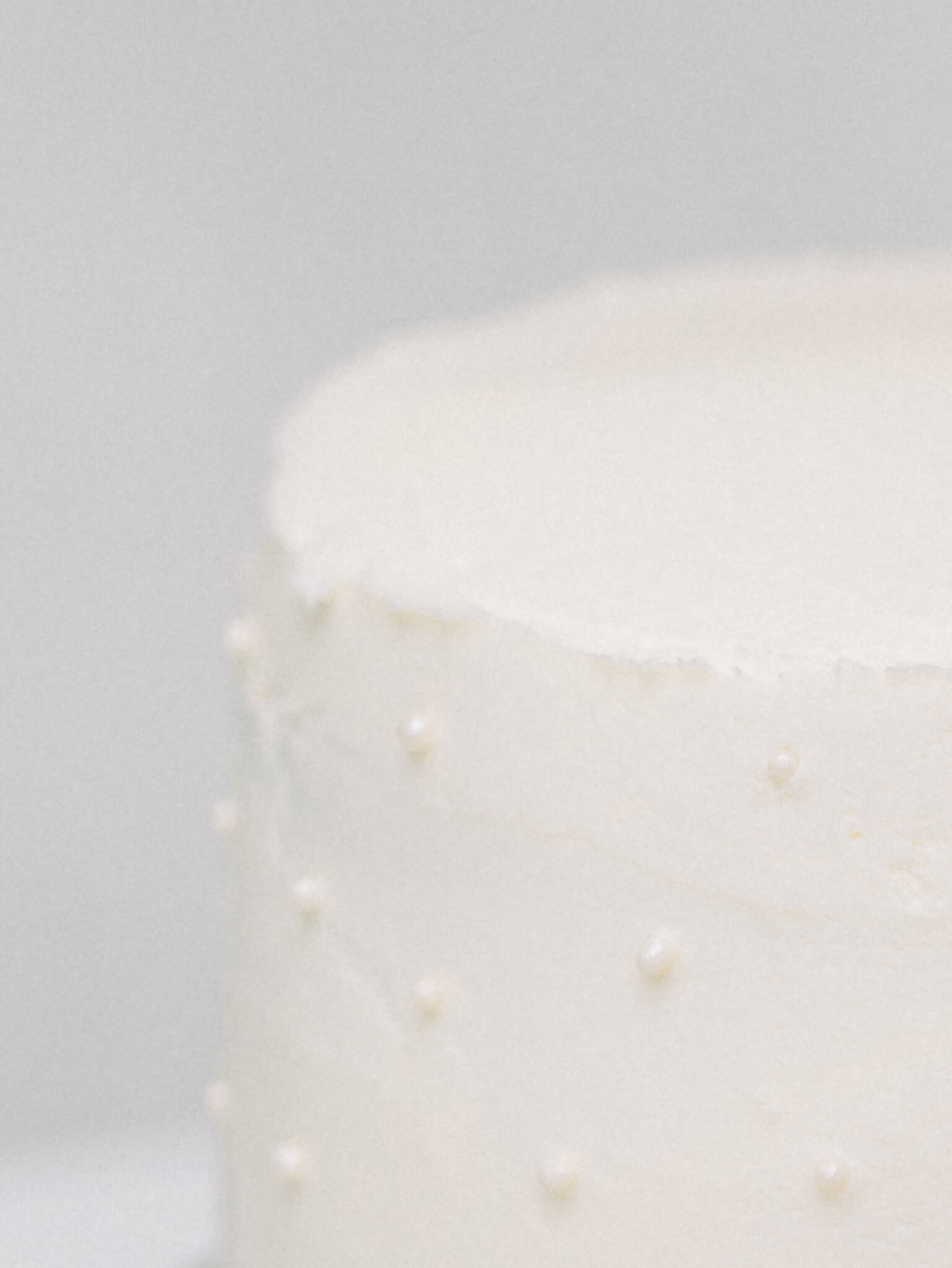 Close-up of a white cake with white pearls.