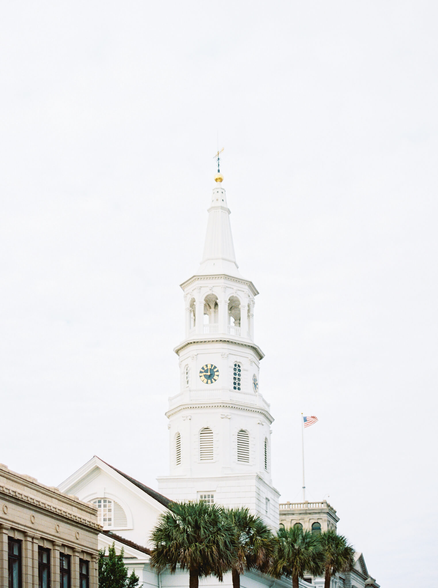 The white steeple of a church curing Charleston Engagement Photos.