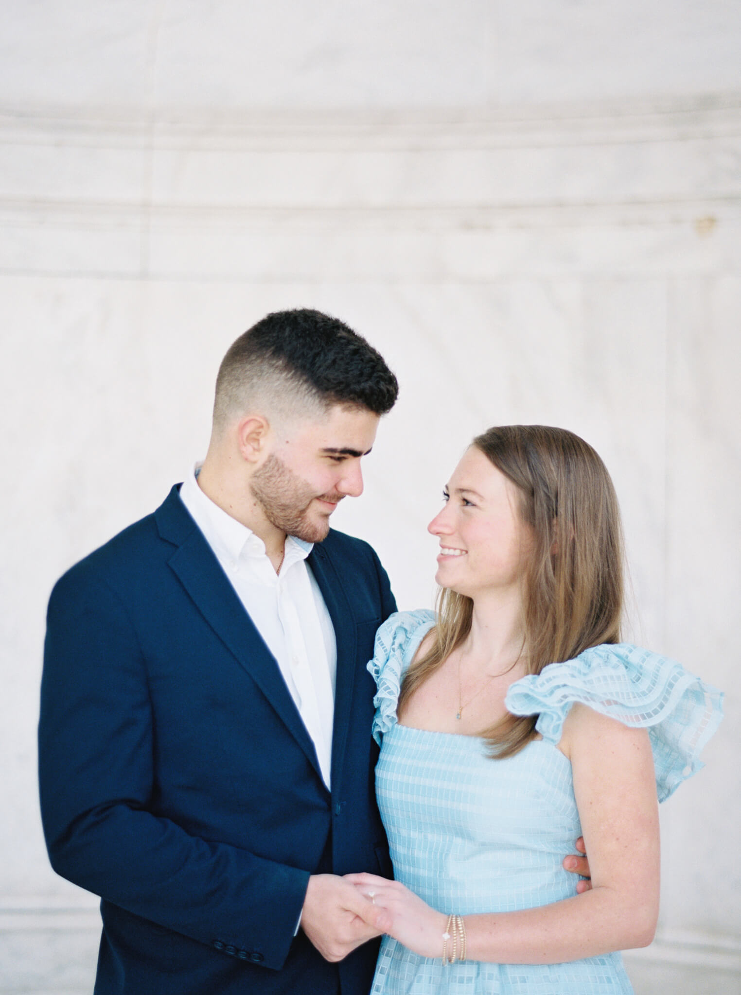 Closeup of a young engaged couple holding hands and looking at each other during their Jefferson Memorial Engagement Photos