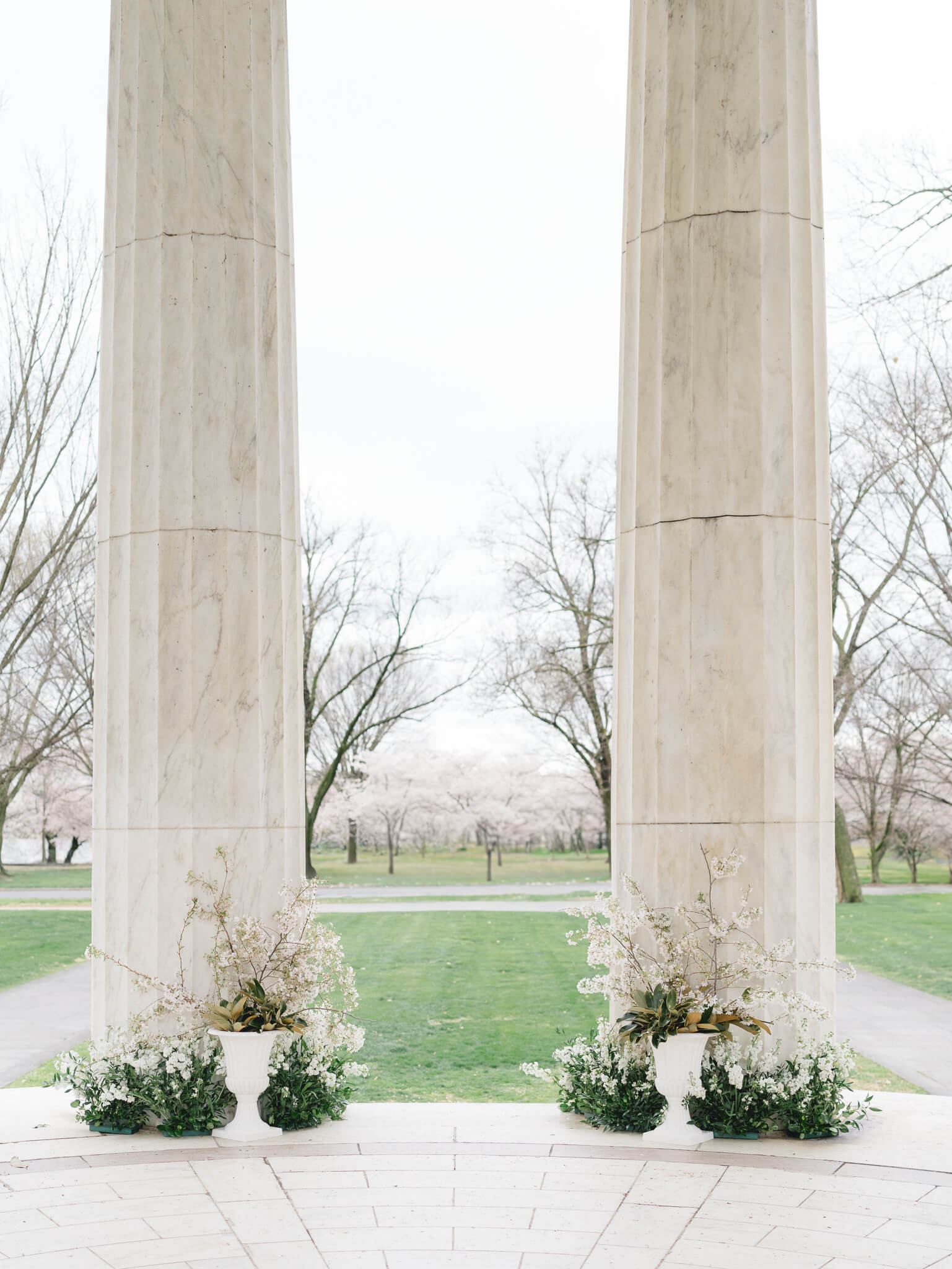 Floral arrangements set up for a cherry blossom elopements under the columns of the D.C. War Memorial