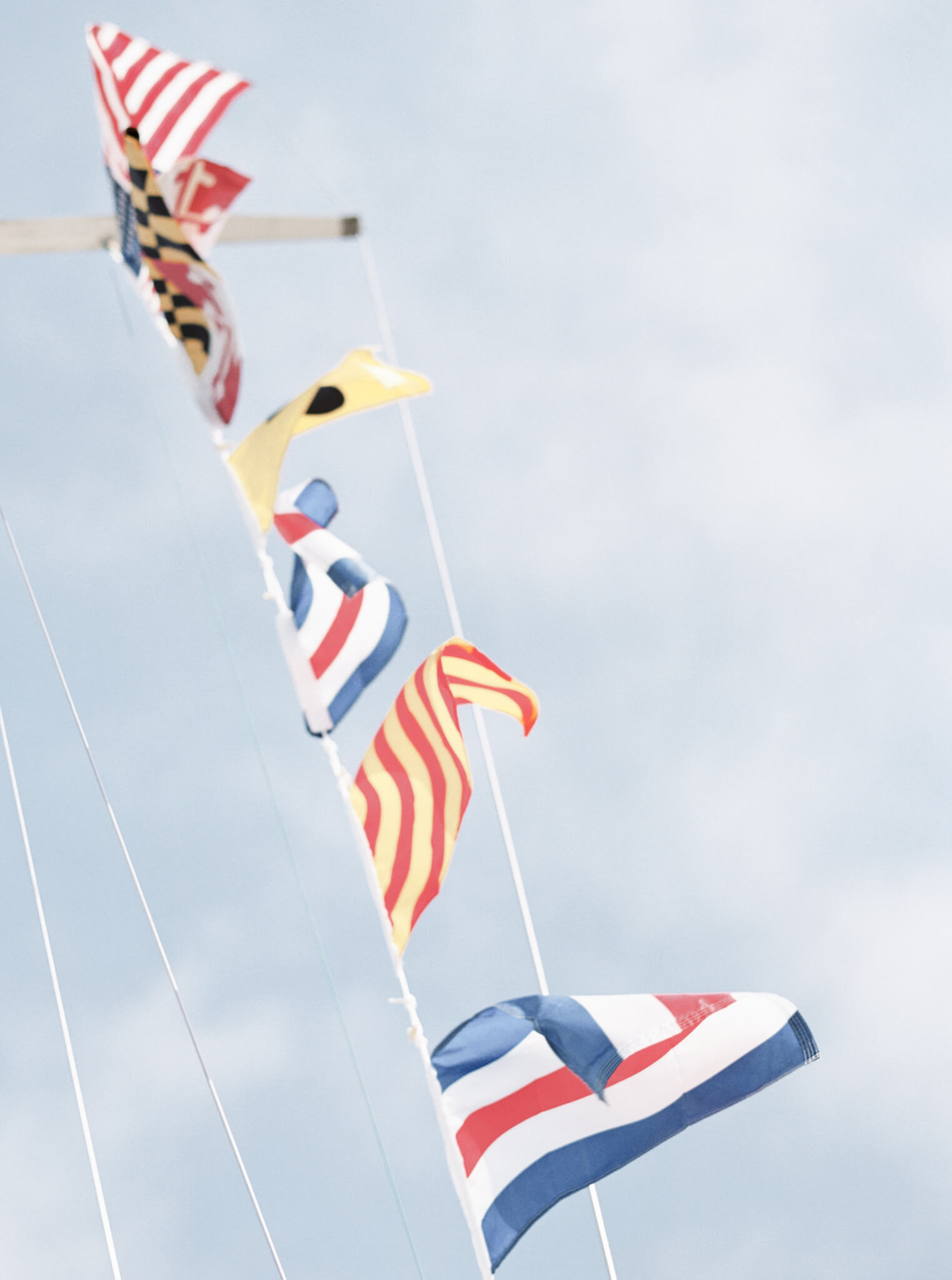 Colorful flags blowing on a sailboat mast.