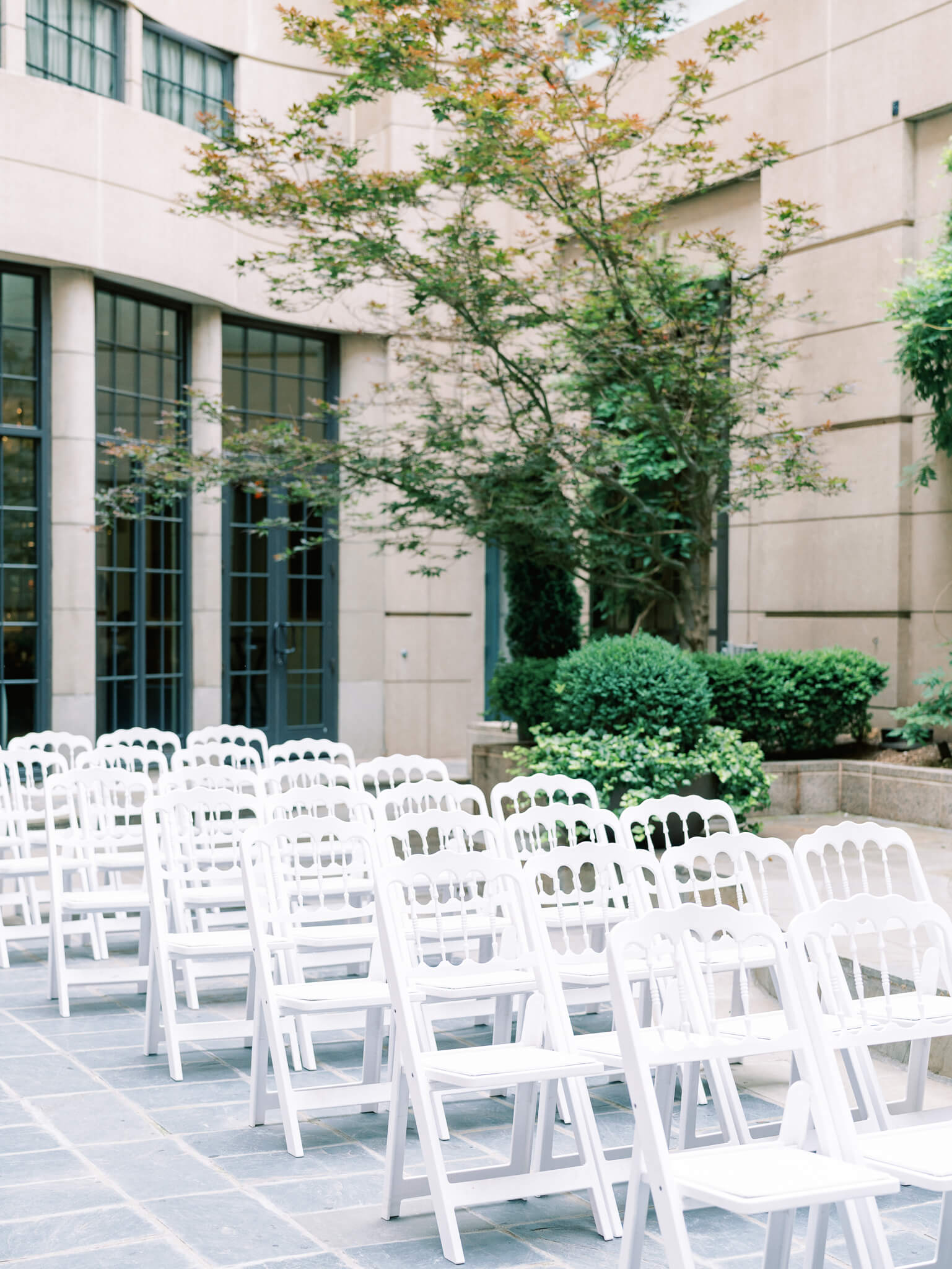 White chairs set up in the courtyard for the ceremony at a Westin Georgetown Wedding.