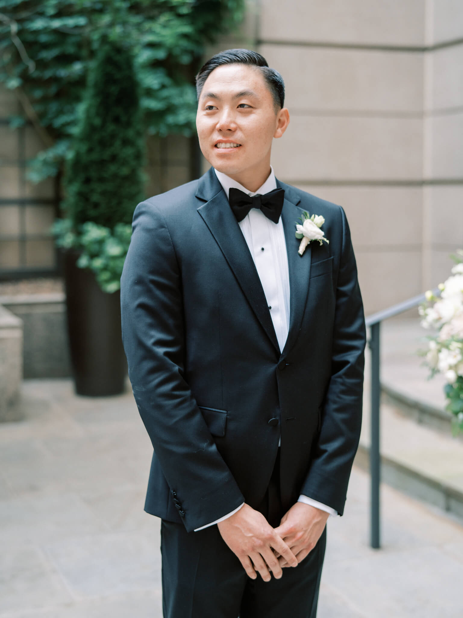 A groom in a black tux waiting at the altar for his bride during their Westin Georgetown Wedding.