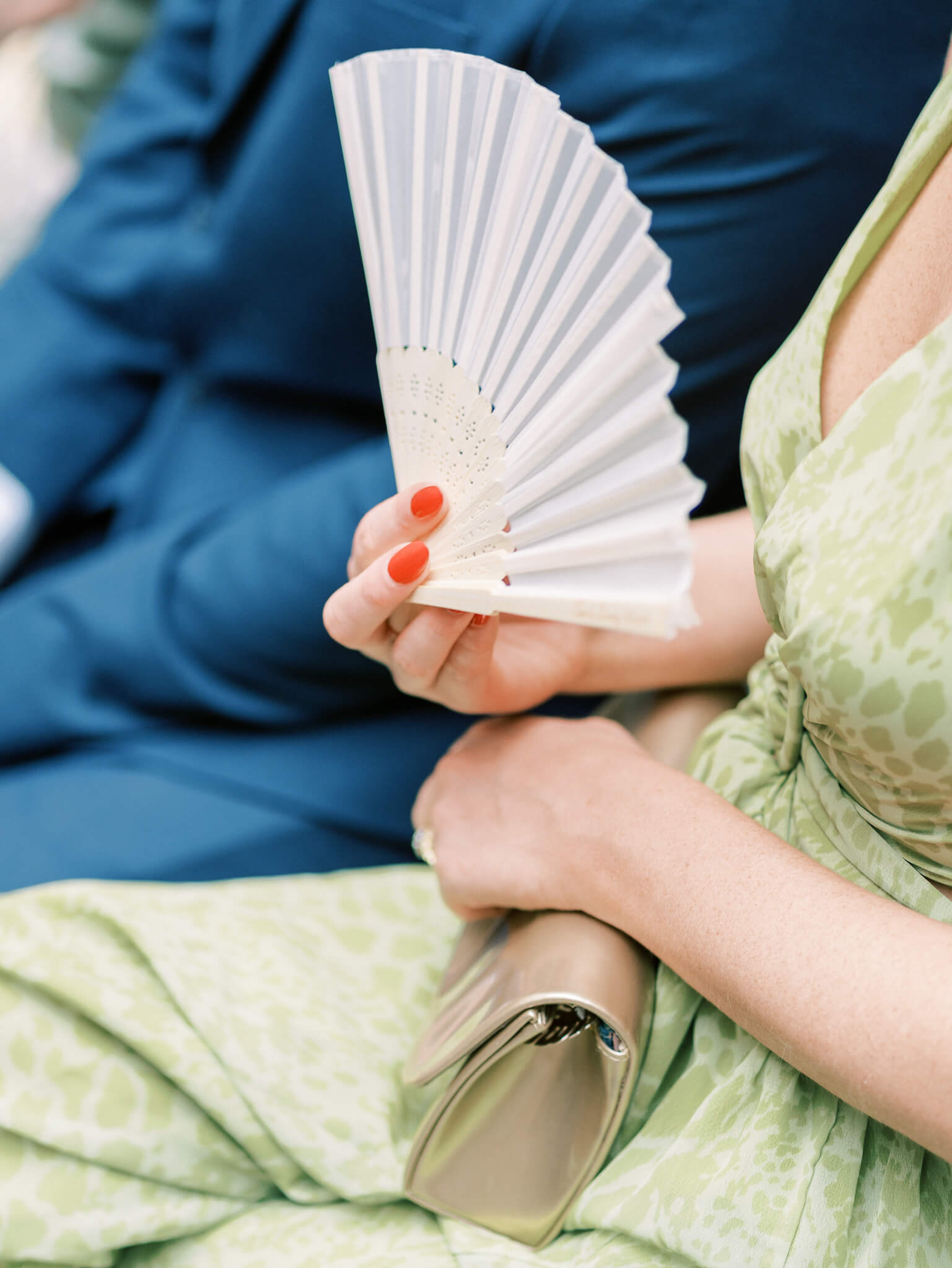 A guest holding a purse and a fan during a ceremony at a Westin Georgetown Wedding.