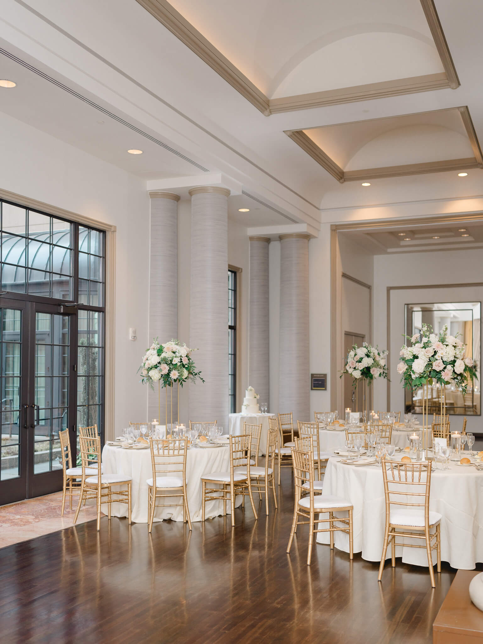 A wedding reception in neutral colors with blush, cream, and green floral centerpieces at the Westin Georgetown.