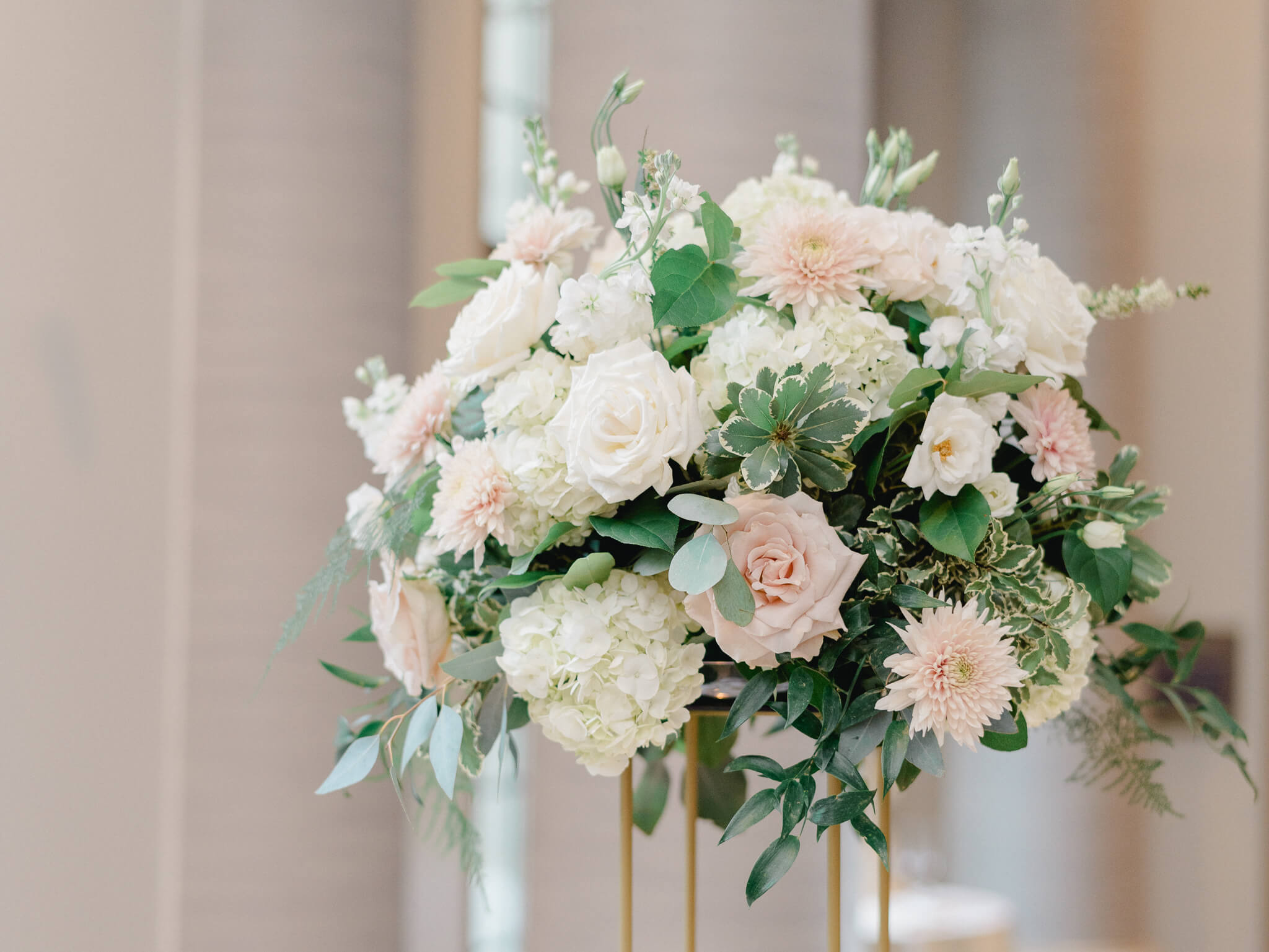 Closeup of a floral centerpiece with greenery, blush roses and white hydrangeas at a Westin Georgetown Wedding.