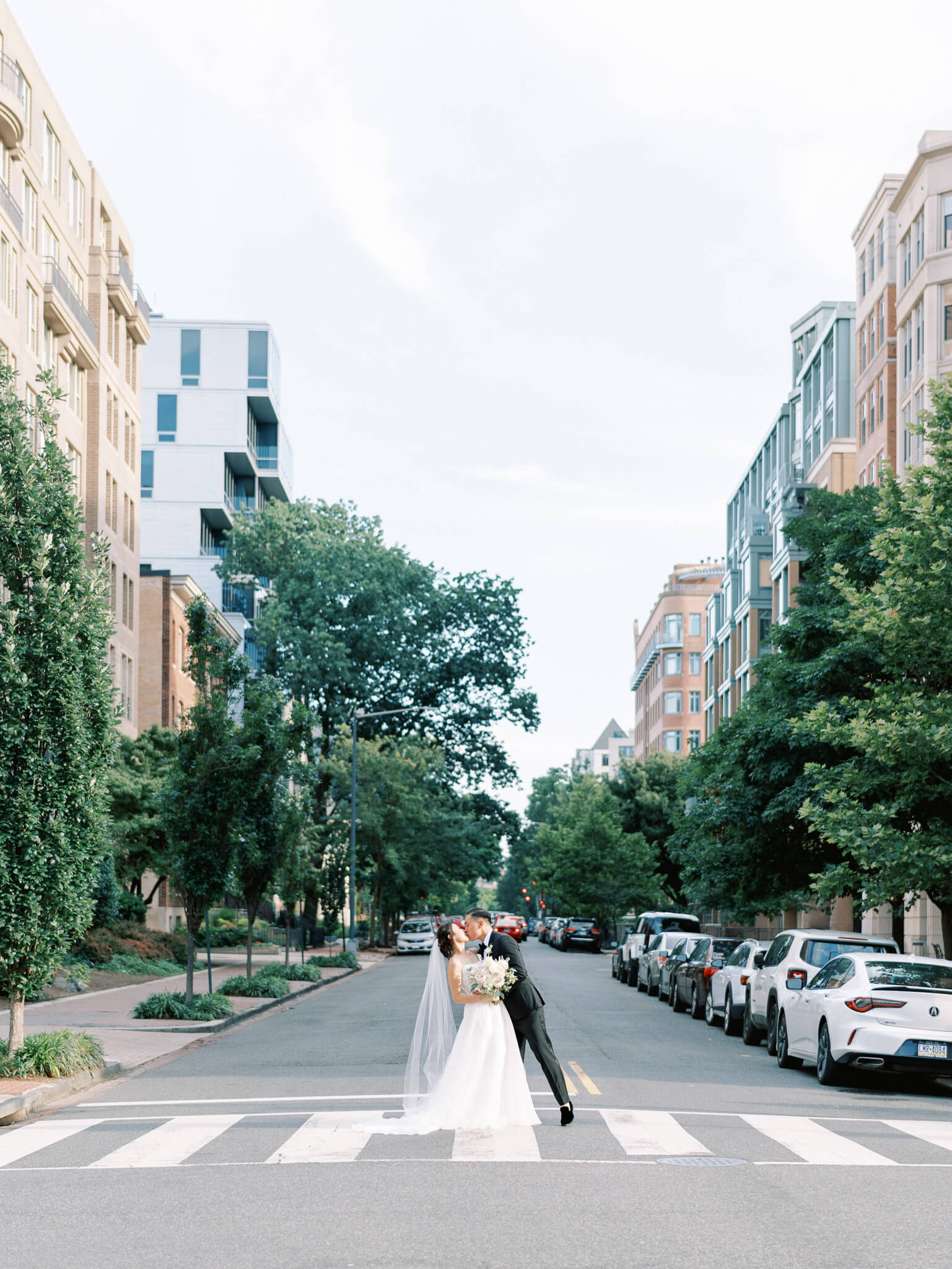 A bride and groom kissing the middle of the crosswalk at their Westin Georgetown Wedding.