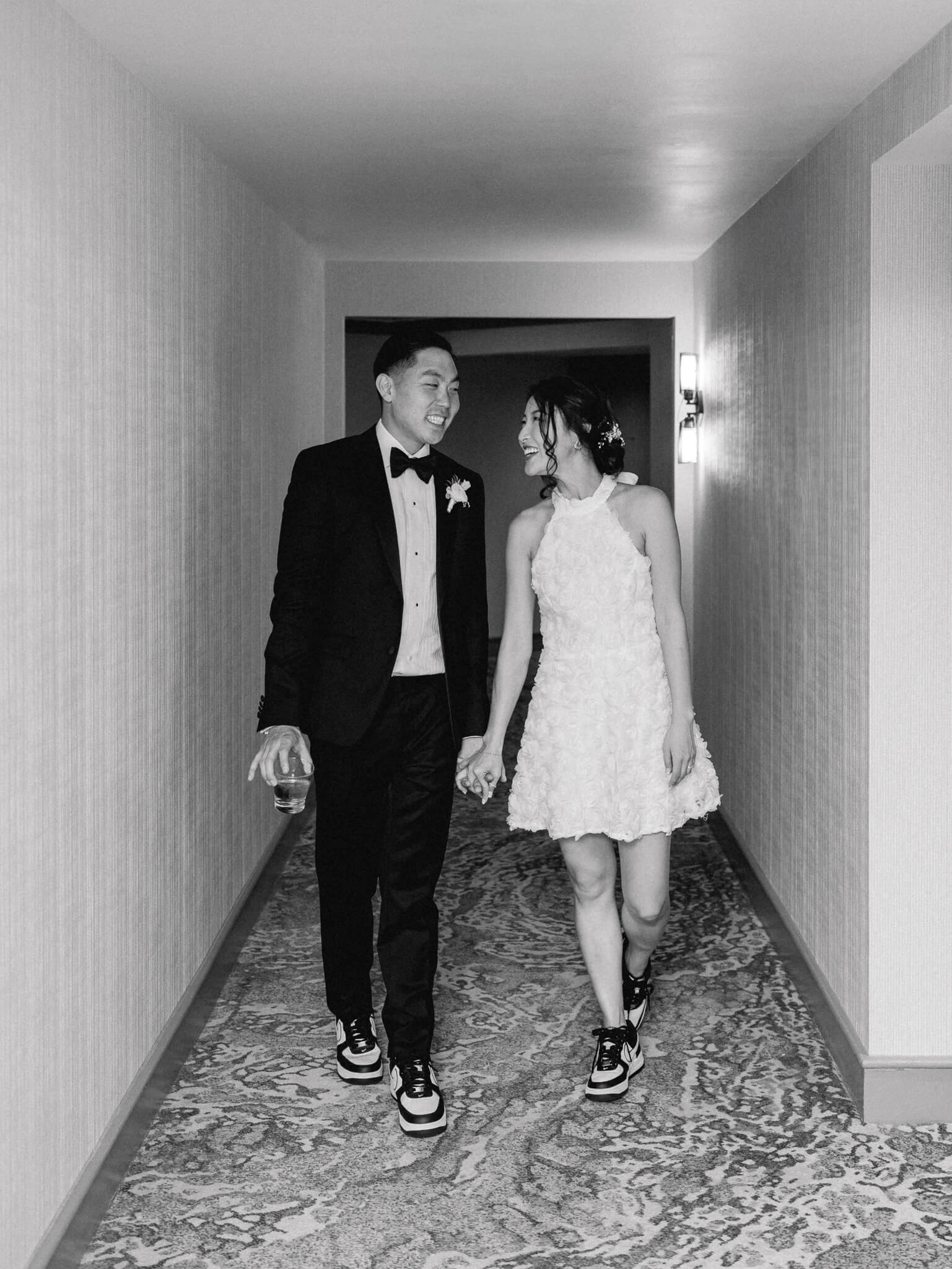 The bride and groom walking down the hallway hand in hand to their suite at the Westin Georgetown in Washington, D.C.