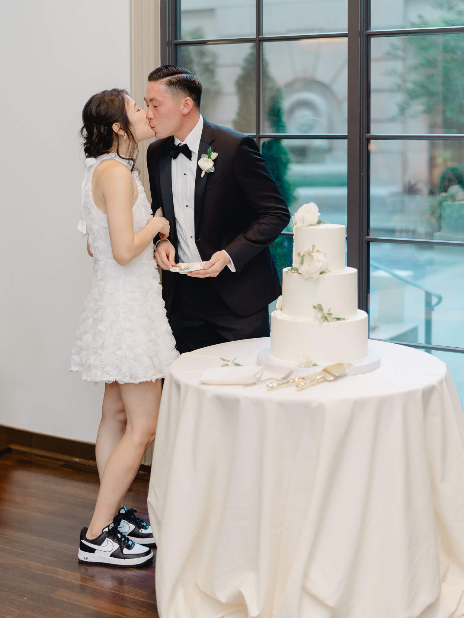 A bride and groom kissing after cutting their wedding cake at their Westin Georgetown Wedding.