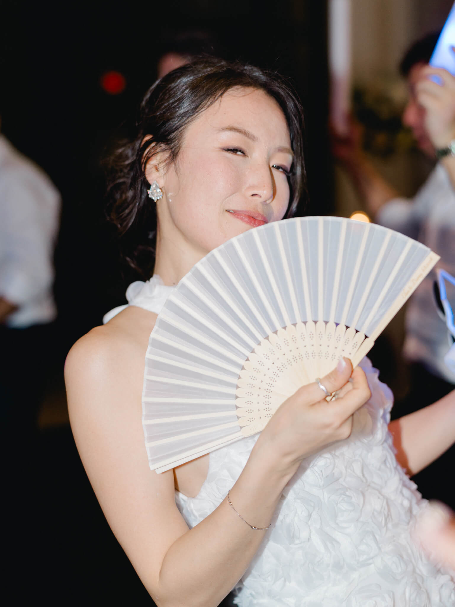 A bride holding a white fan on the dance floor at a Westin Georgetown Wedding.