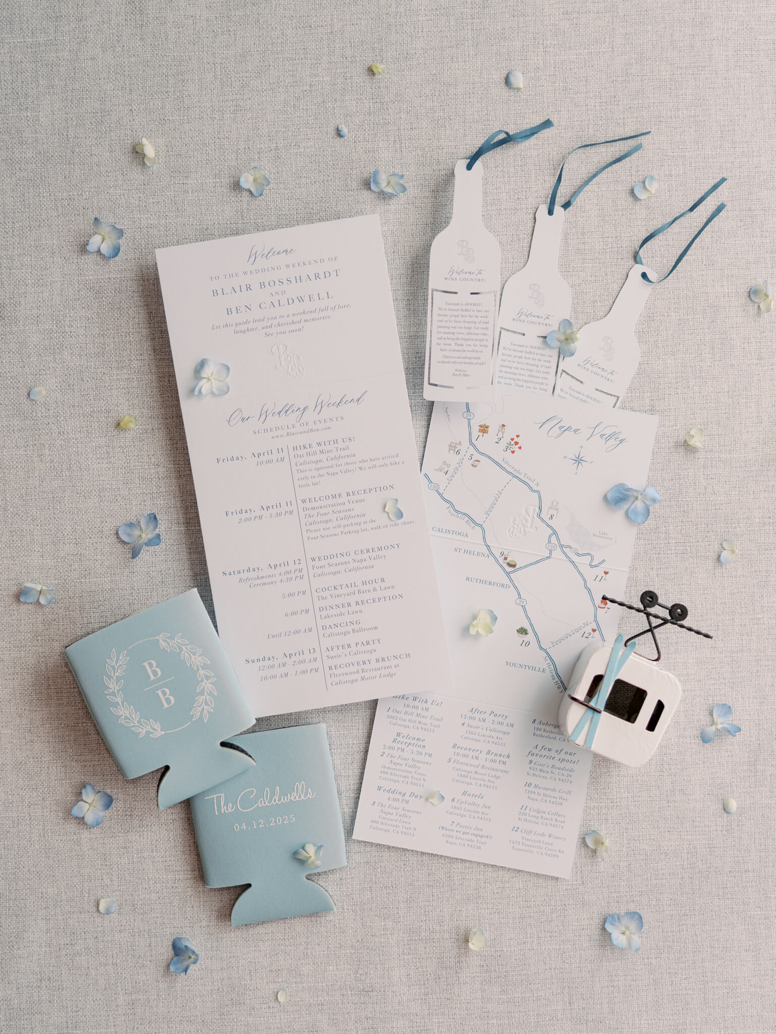 Flatlay of an invitation suite with koozies, a gondola, and wine shaped stationary.