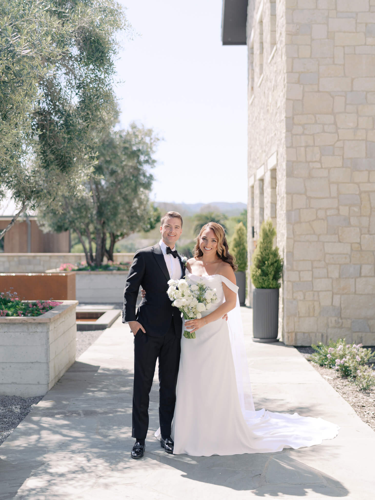A traditional portrait of a newlywed couple wearing a tux and wedding dress.