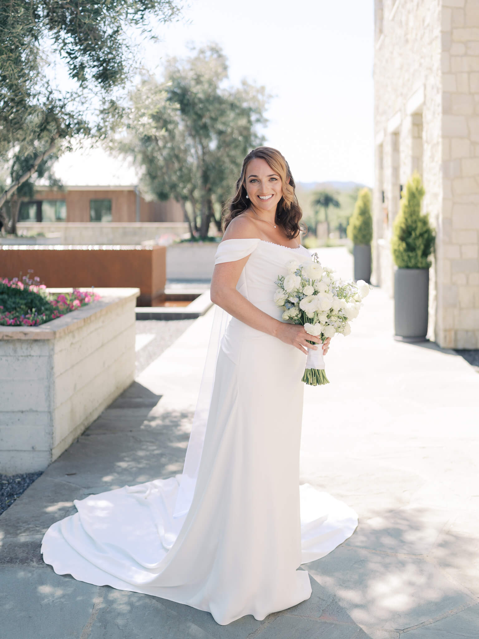 Full length portrait of a bride on her wedding day, holding her bouquet.