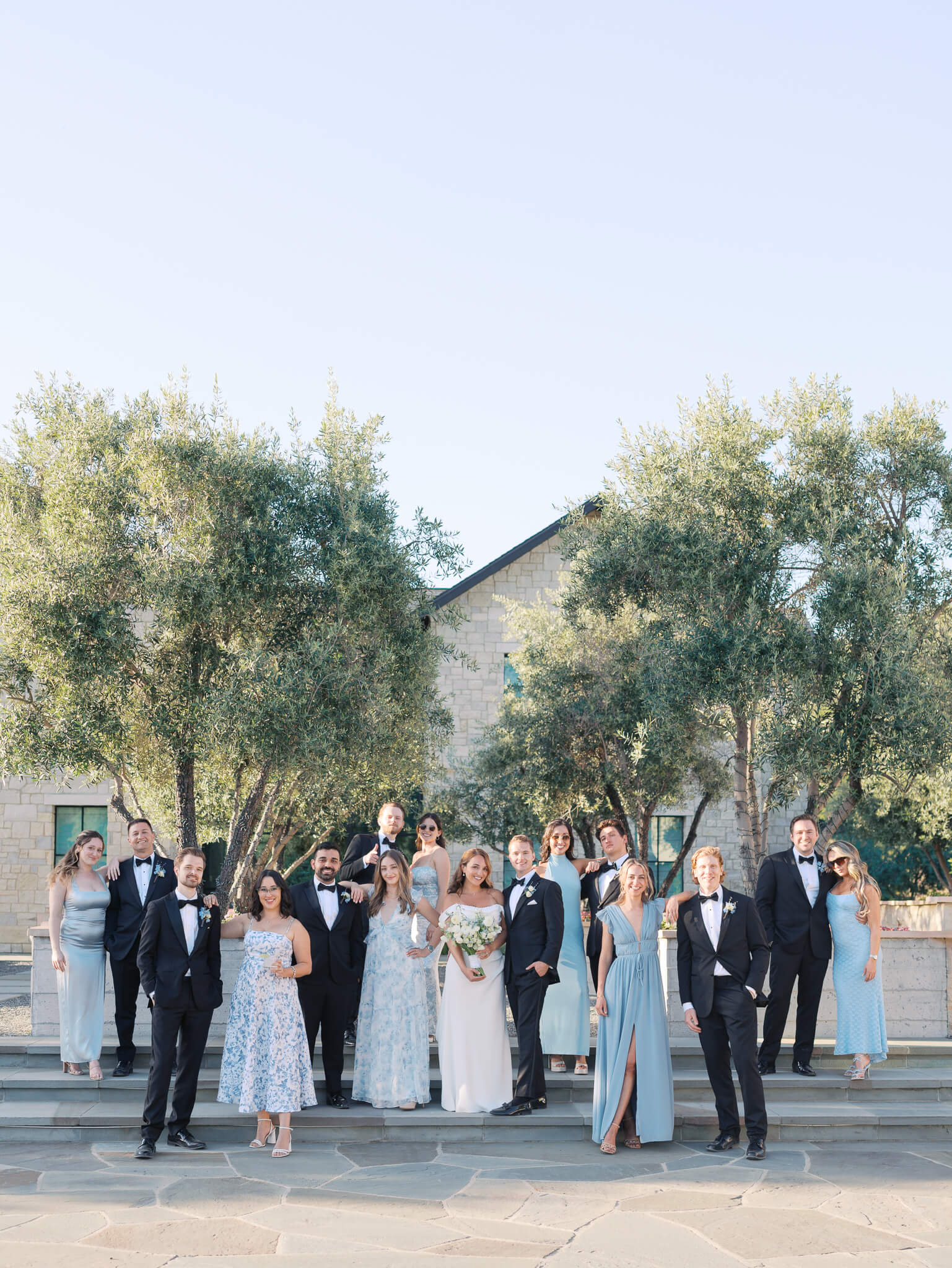 A full wedding party dressed in black and shades of blue at a destination wedding weekend.