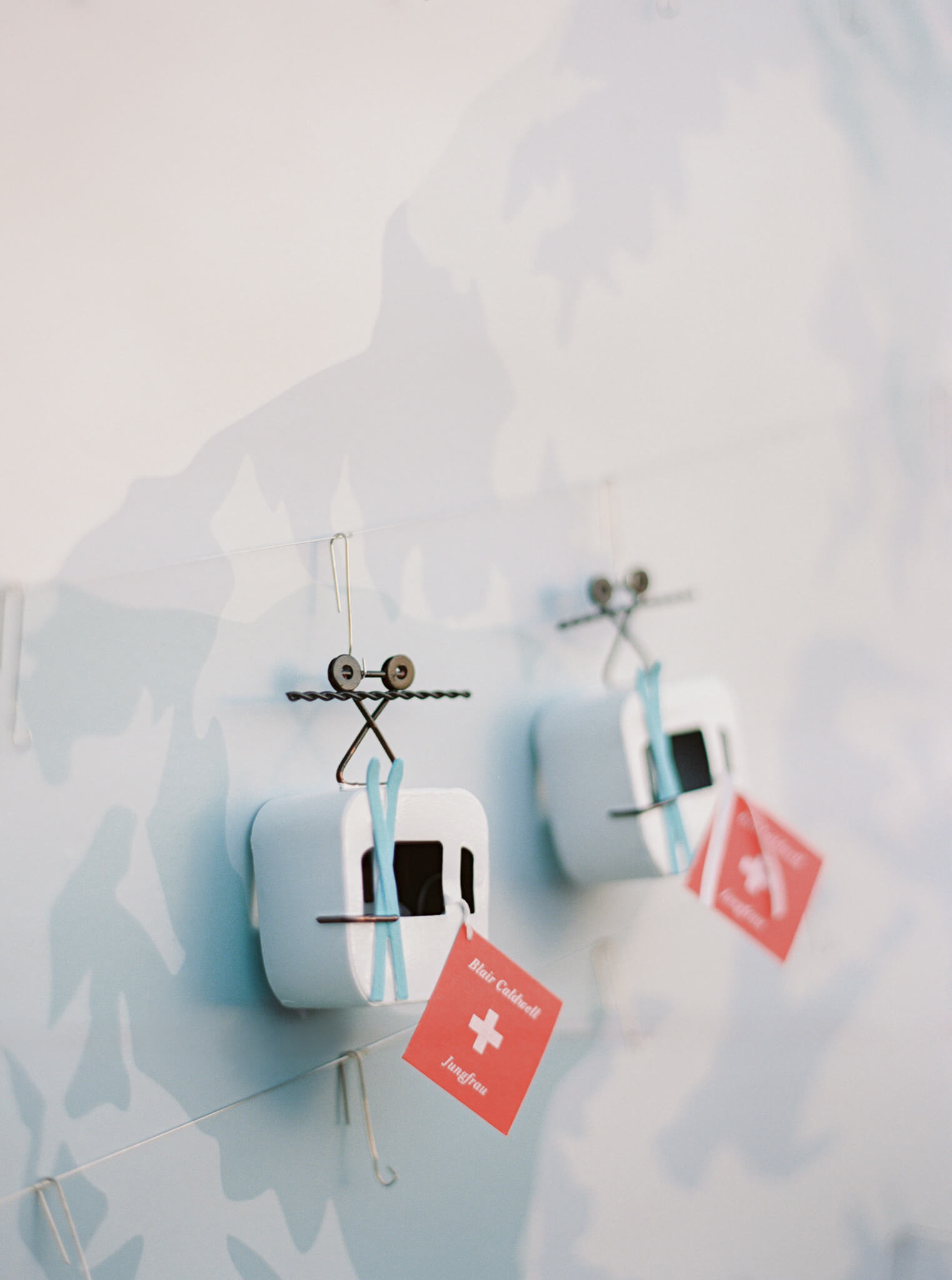 White gondolas on an escort display with blue skies and red name tags. 