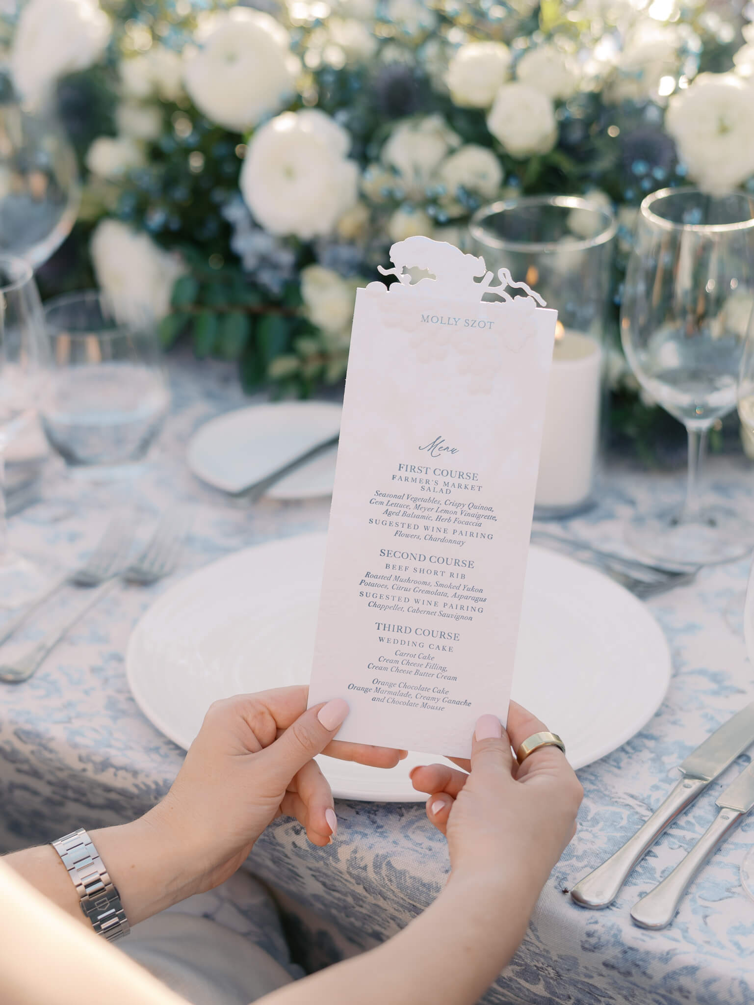 A female wedding guest's hands holding a menu.