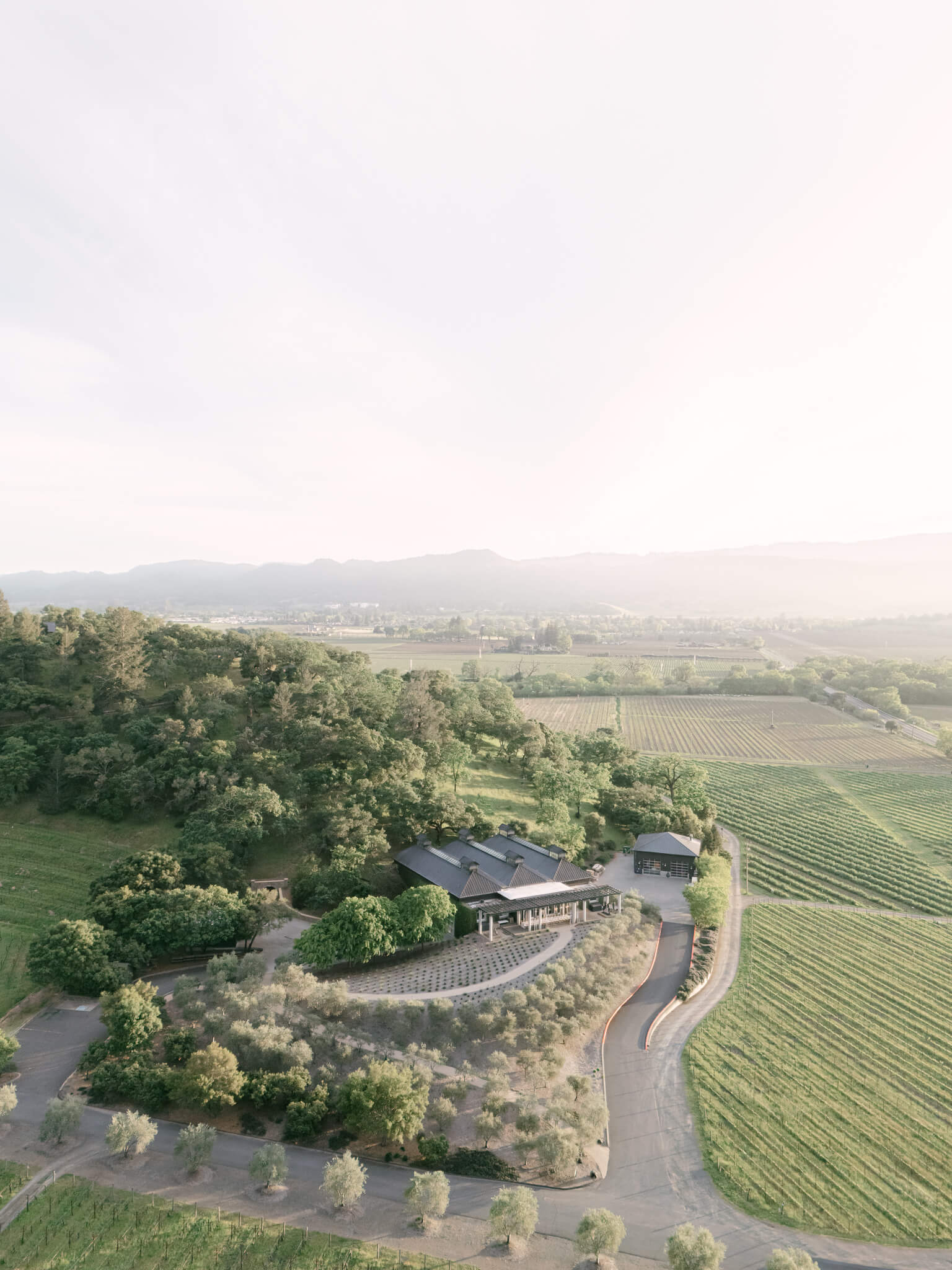 Drone image of a destination wedding vineyard venue set in the hillside at sunset.