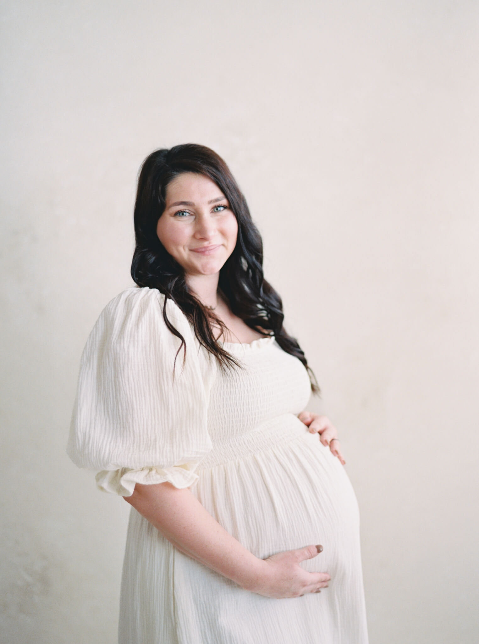 Closeup of a pregnant woman in a cream dress during her Annapolis maternity photos.