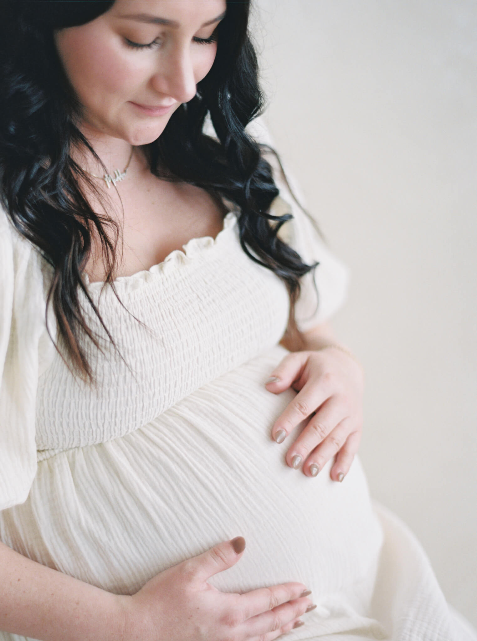 Closeup of a pregnant mother looking down at her belly during her maternity session in Annapolis.