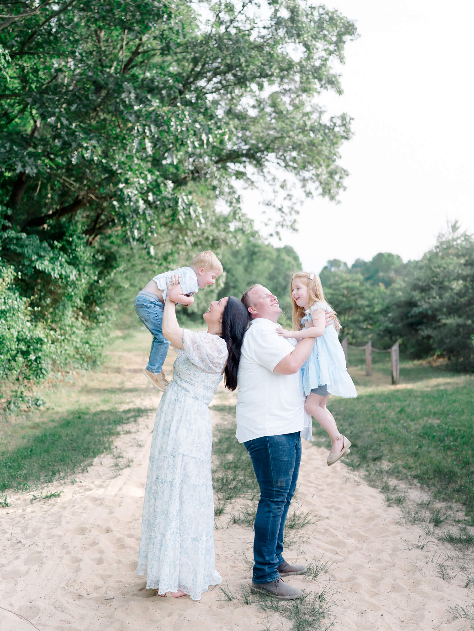 A mom and dad lifting their son and daughter up in the air during their Annapolis Family Photos.