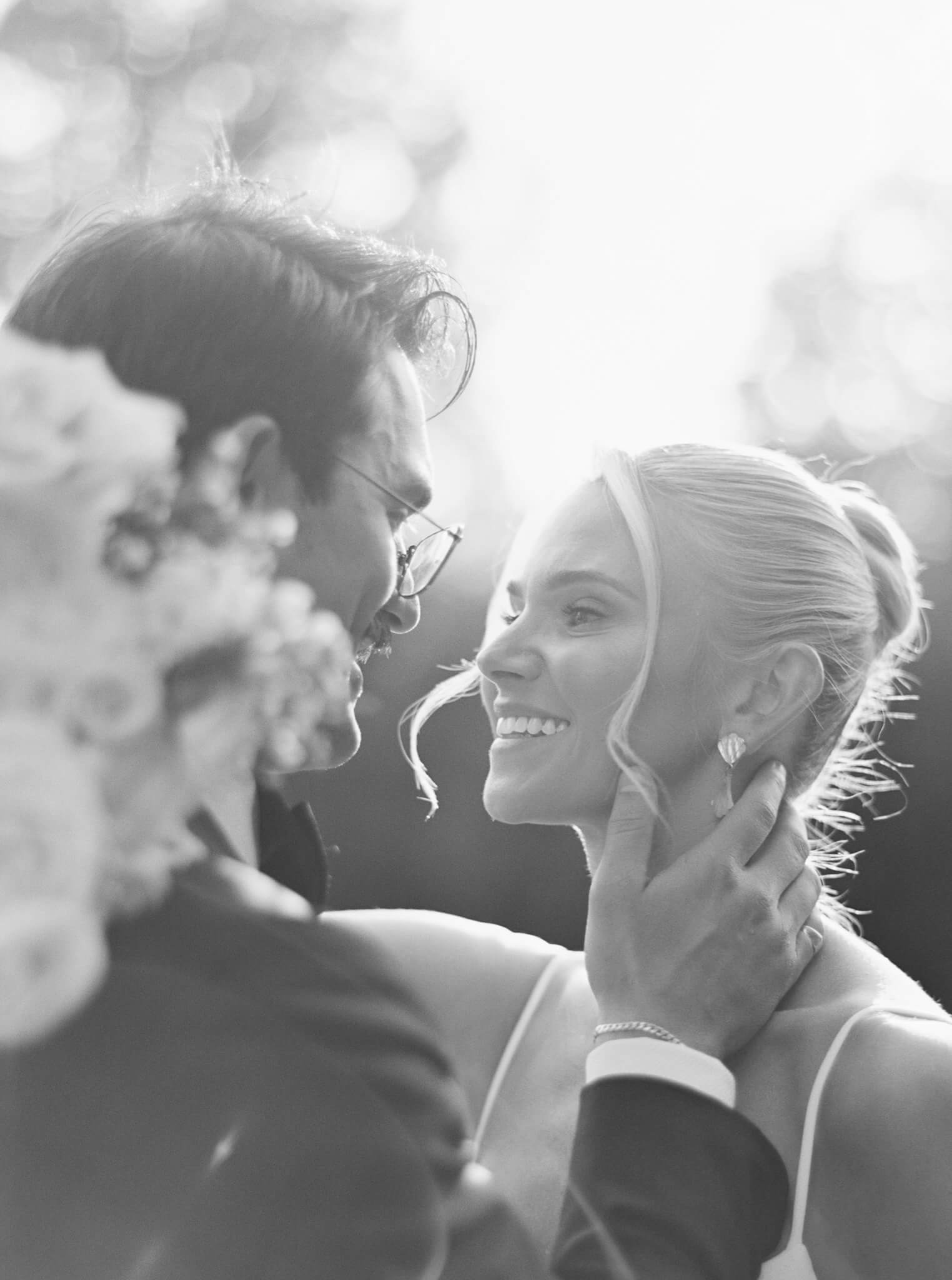 Closeup black and white image of a groom leaning in to kiss his bride at their Rust Manor House wedding.